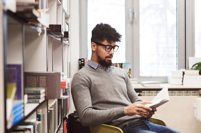 Smiling African American young man studying in a library