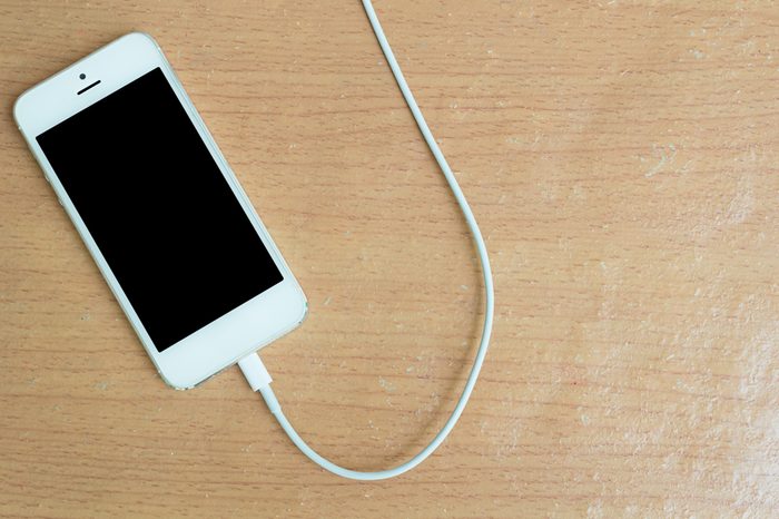 USB cable with smartphone on wood table 