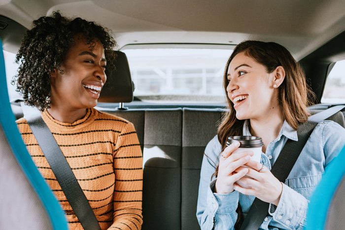 two women talking in the backseat of a car