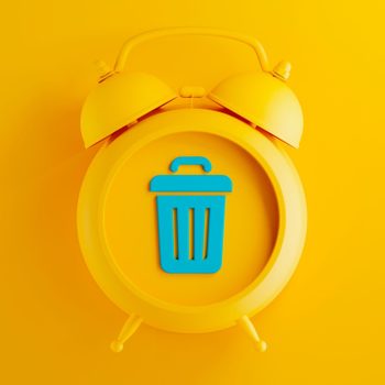 yellow alarm clock on yellow background with blue trash can symbol
