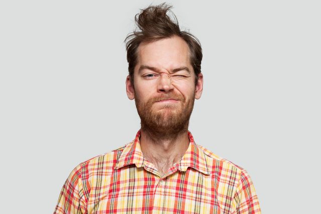 portrait of a disheveled man. gray background.