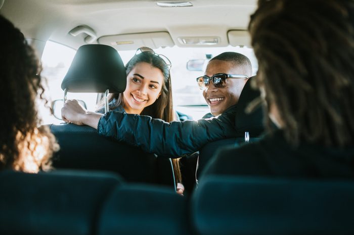 young adults enjoy a road trip on a sunny day. Mixed ethnic group.