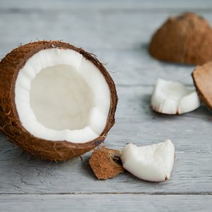 broken fresh organic coconut on rustic wooden grey background