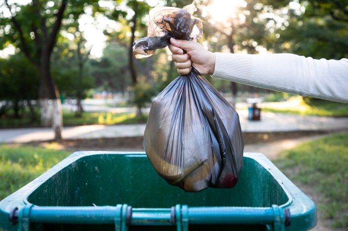 Throw the garbage bag into the trash can