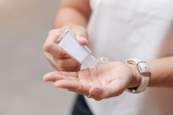 Woman hands using wash hand sanitizer gel dispenser, against Novel coronavirus (2019-nCoV) or Wuhan coronavirus at public train station. Antiseptic, Hygiene and Healthcare concept