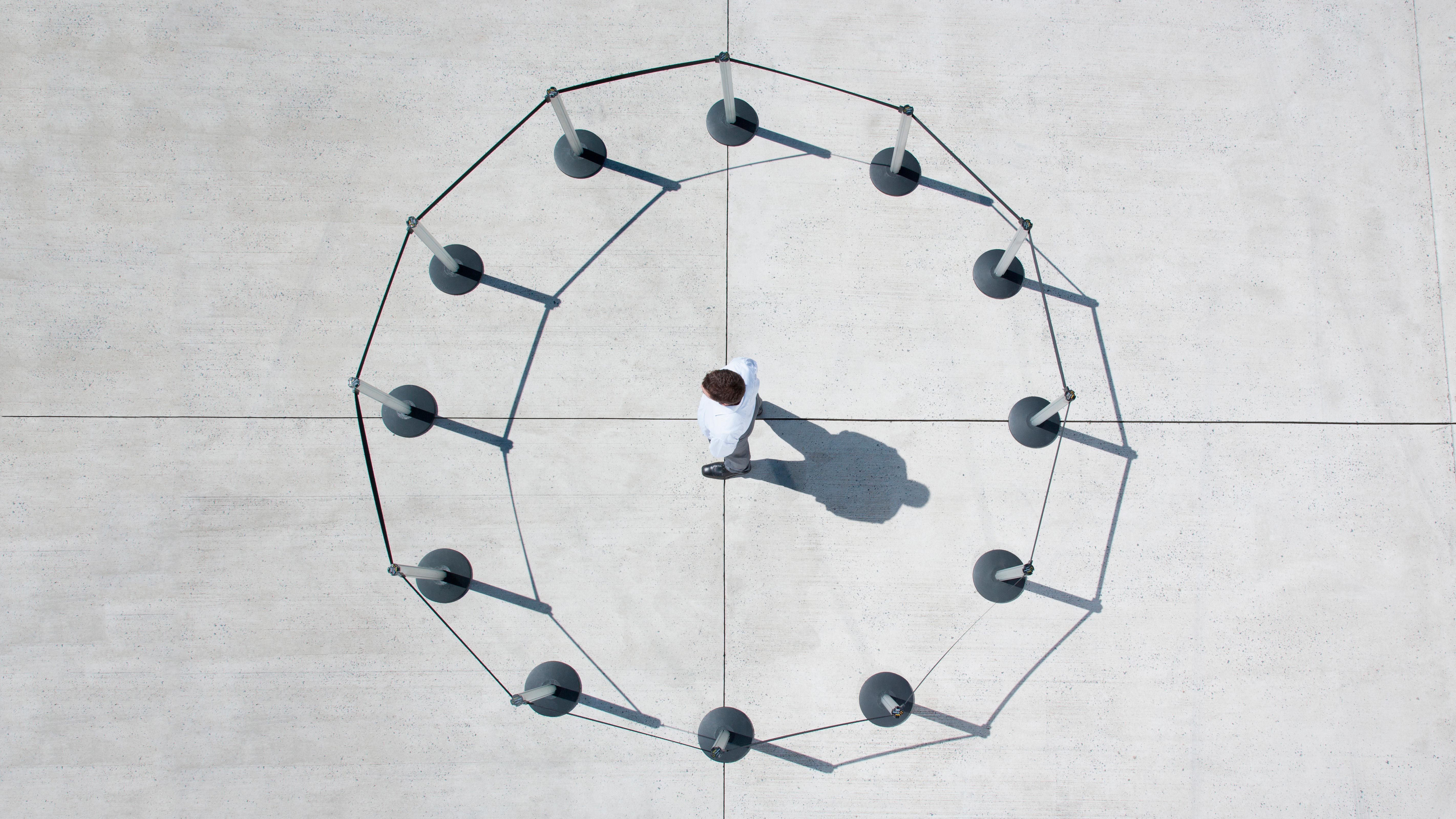 overhead view of a man within a circle of cordon posts