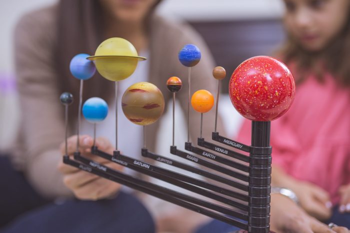 Ethnic mother cheerfully studying astronomy with her daughter