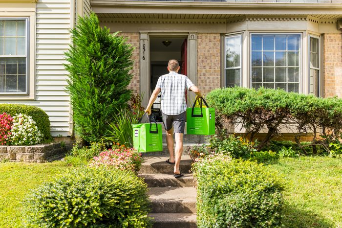 Amazon Fresh insulated grocery delivery bags totes on front home house porch closeup with man carrying