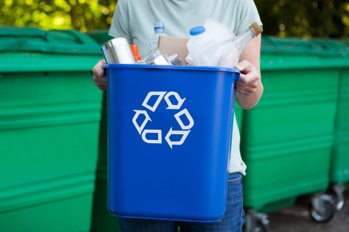 Close Up Of person Carrying Recycling Bin