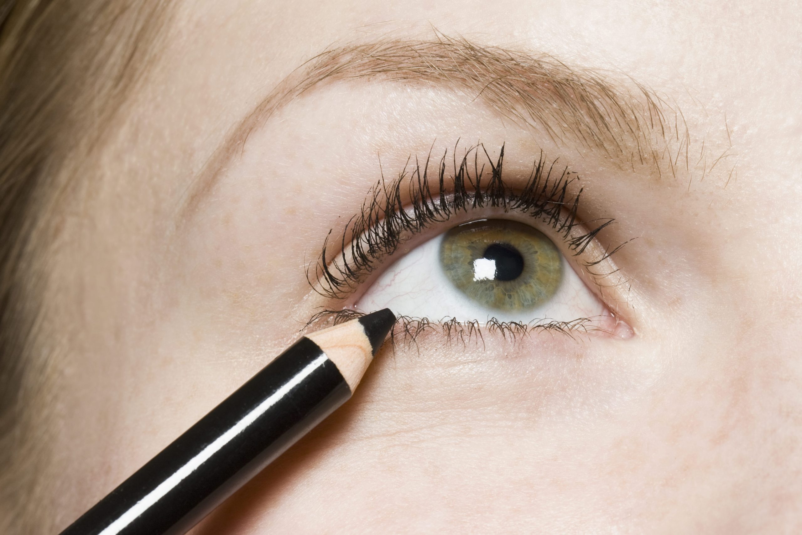 A woman applying eyeliner, detail of eye