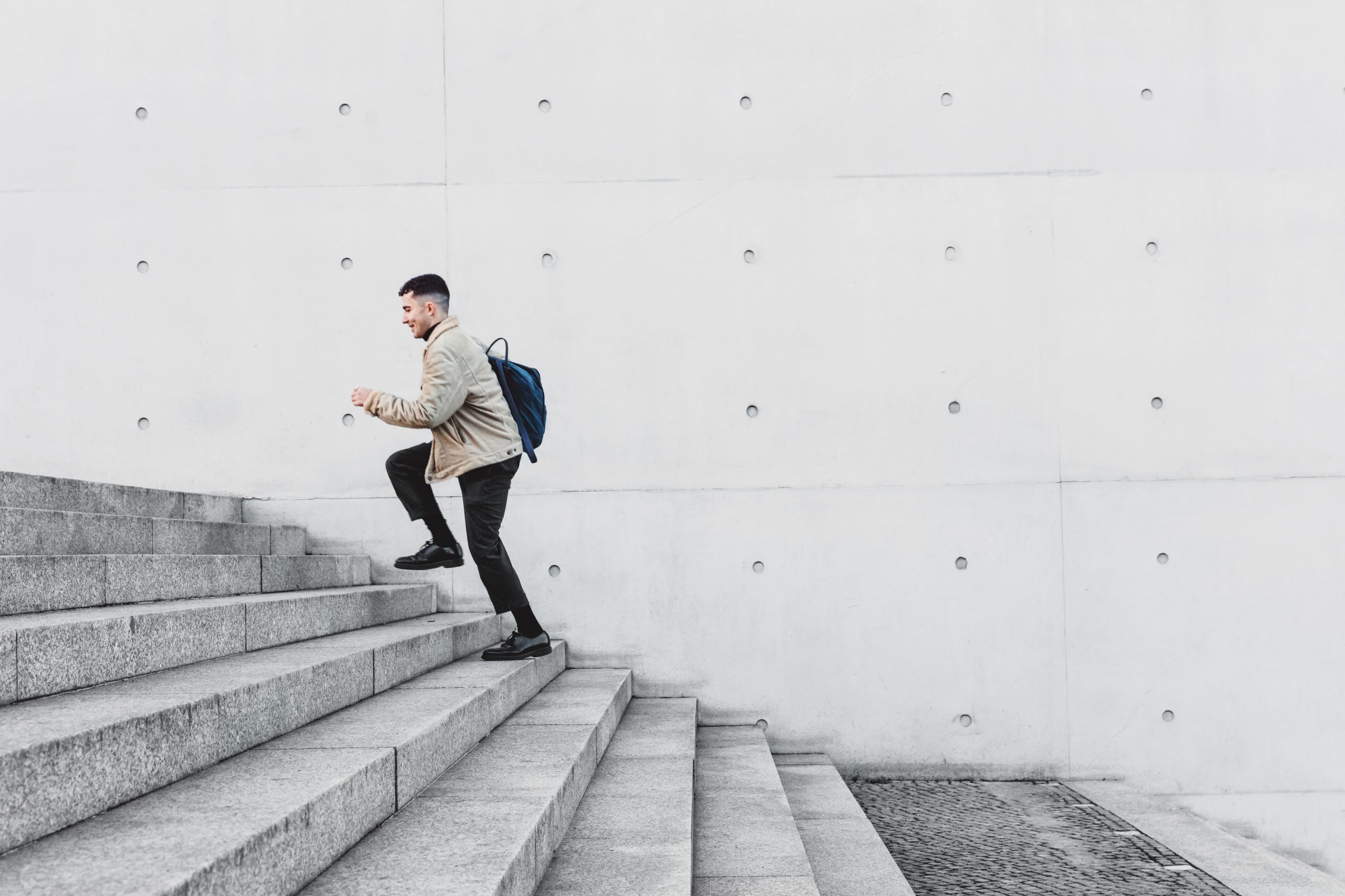 Young man running up steps in urban setting