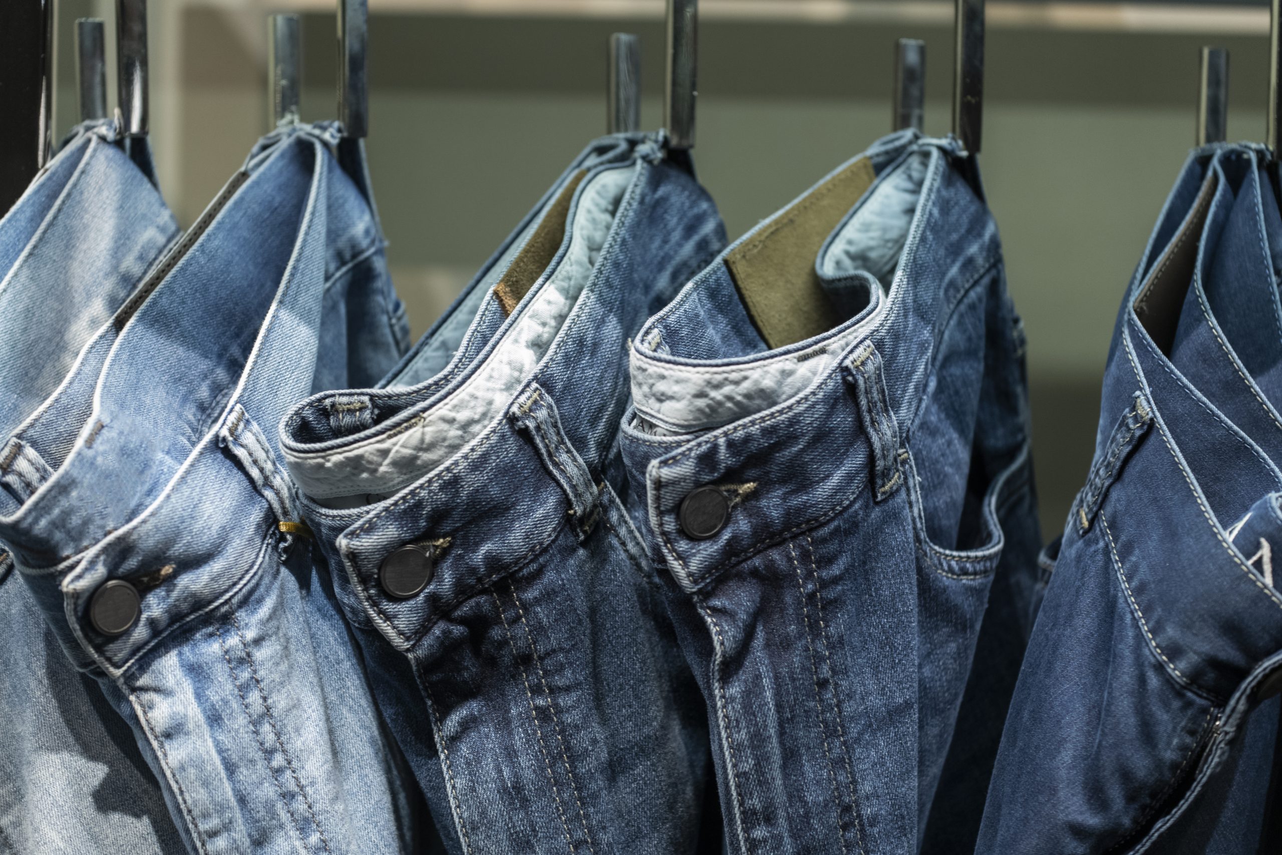 Close up of jeans hanging on clothe sack in a row
