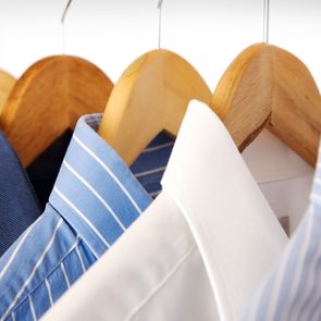 dry cleaned shirts on wooden hangers
