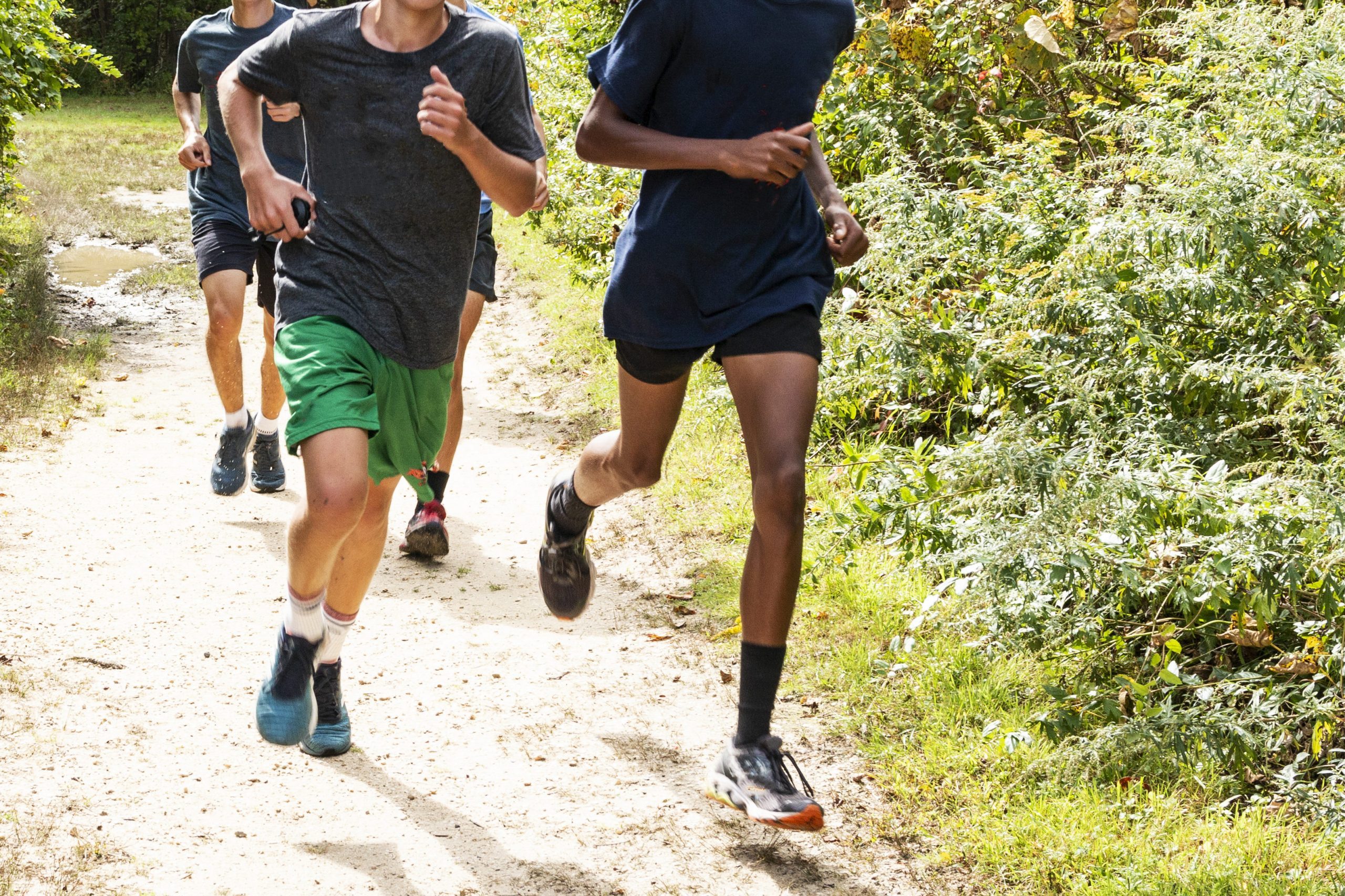 Group of high school boys running on a path