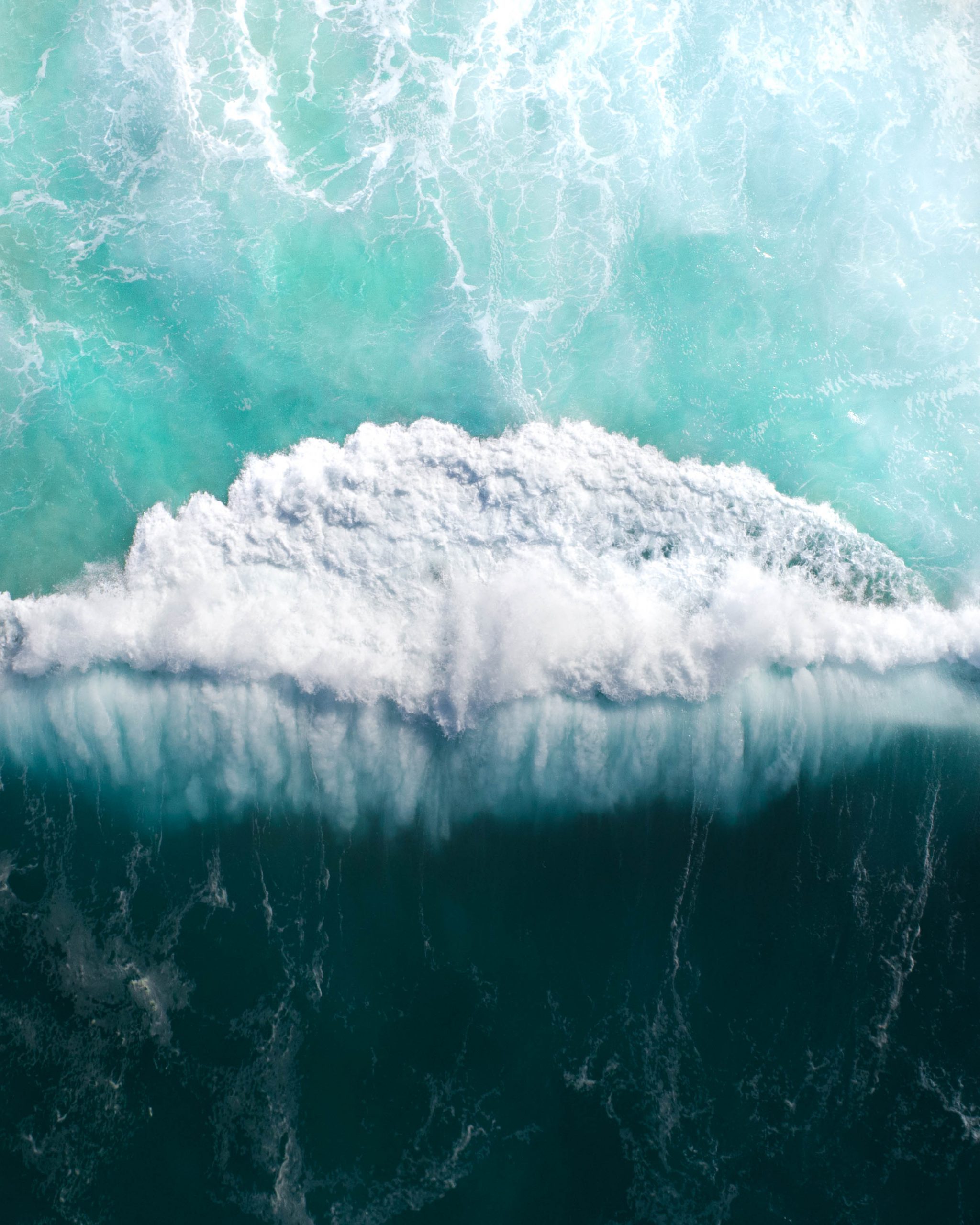 Top view of the ocean and a massive wave crashing. Storm wave breaking in the sea, ocean