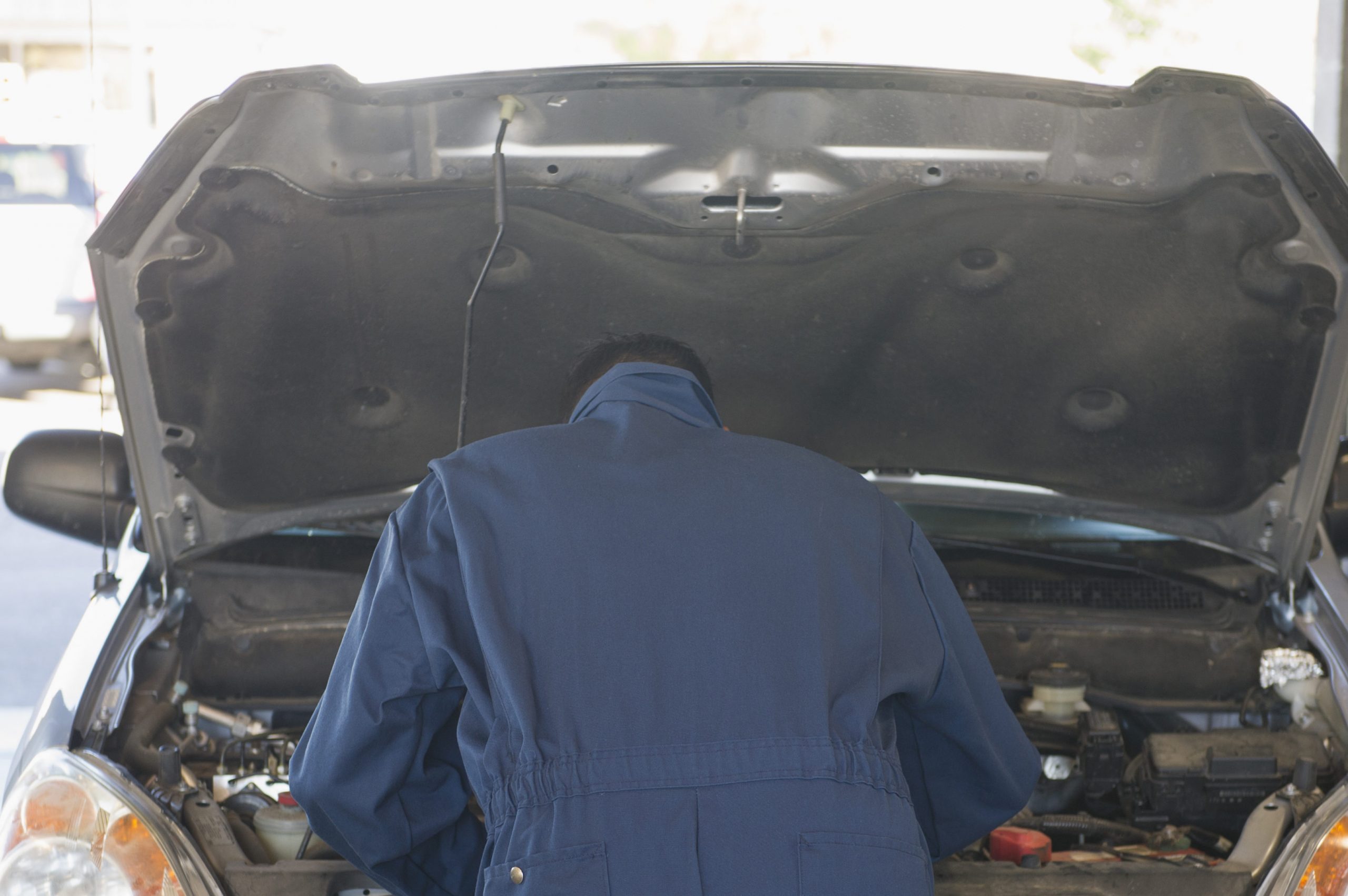 Hispanic worker working on automobile engine