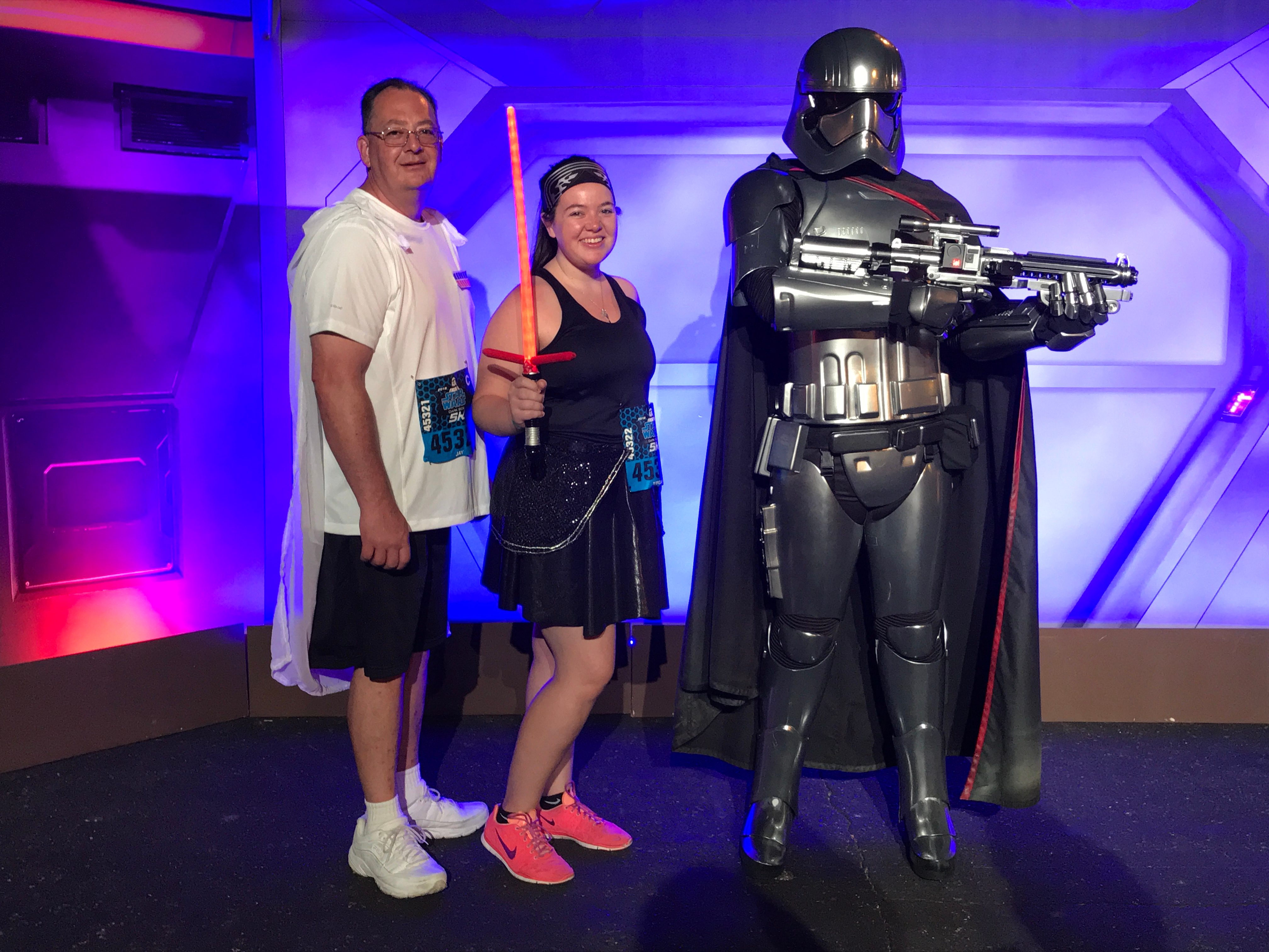 megan dubois and her dad pose next to a star wars character at the 5k race