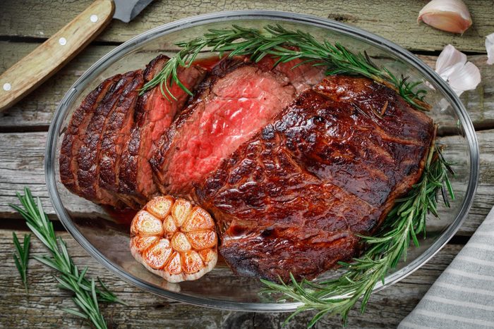 Close-Up Of Cooked Meat With Rosemary And Garlic In Bowl On Table
