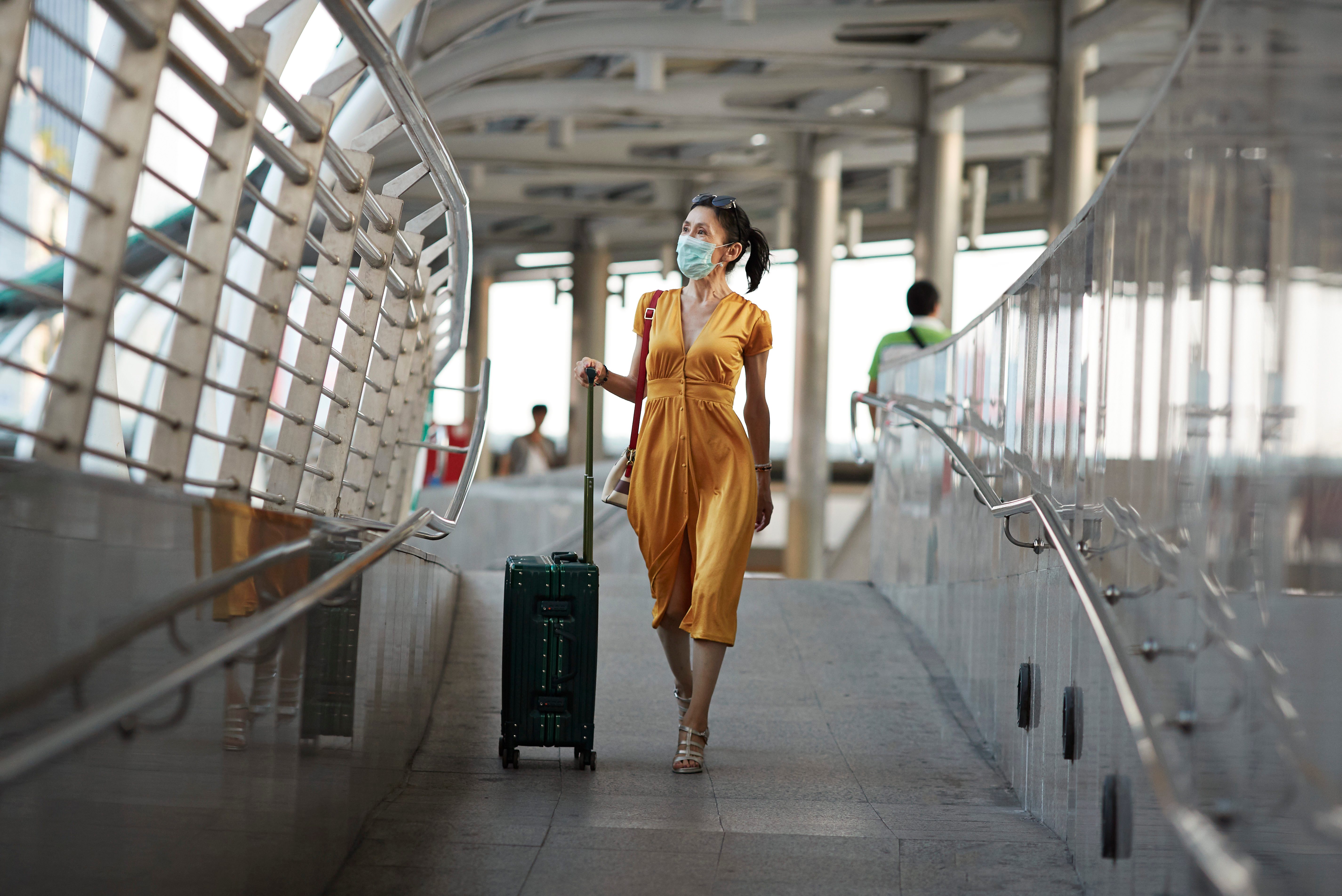 Woman walking with luggage at railroad station