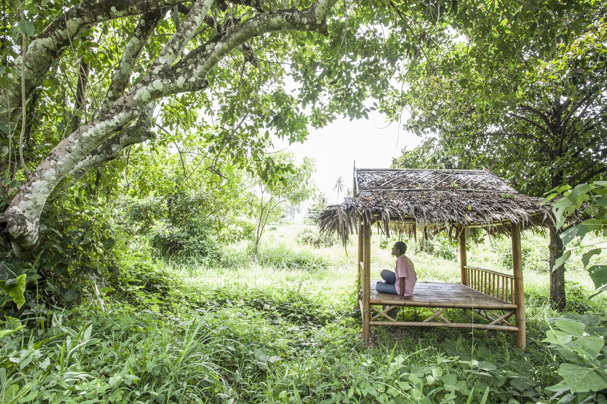 Man sitting in bamboo hut in the jungle