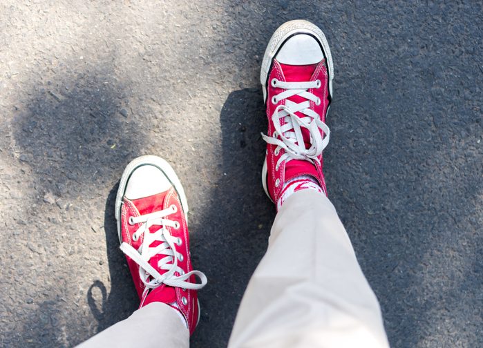 Low Section Of Man Standing On Road