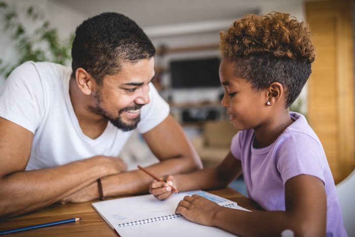 Lovely daughter and father doing homework