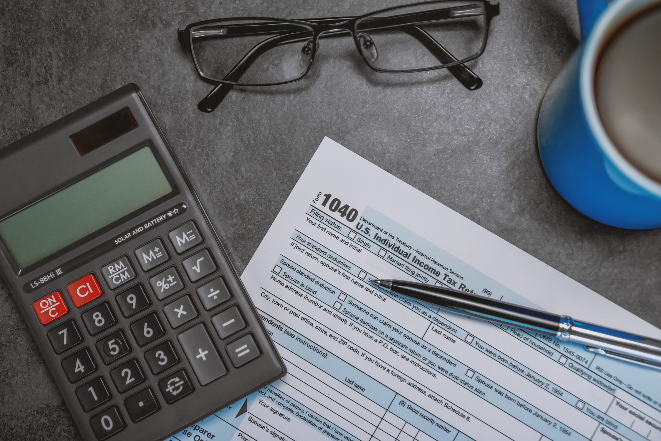 Printed Tax Form on Work Desk with Calculator and Pen