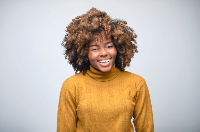 Portrait of cheerful female owner with curly hair