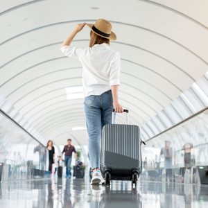 Young woman wearing casual clothes and walking in the airport hall