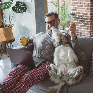 dog leaning over onto owner sitting on couch