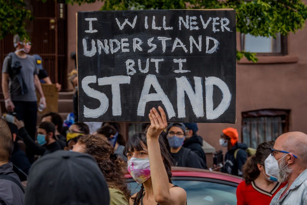 A participant holding a sign at the protest. Thousands of...