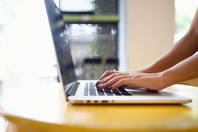 Woman's hands on a laptop on a table