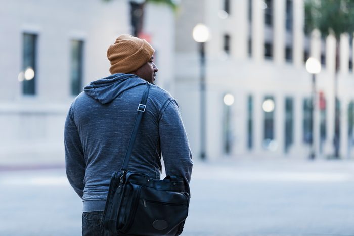 Rear view of mature Hispanic man walking in city