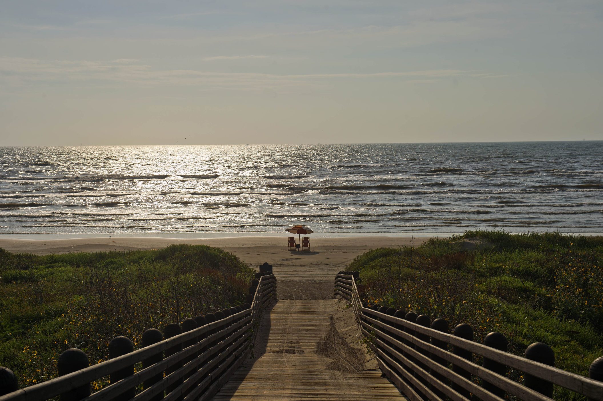 A Deserted Beach And Sun Chairs