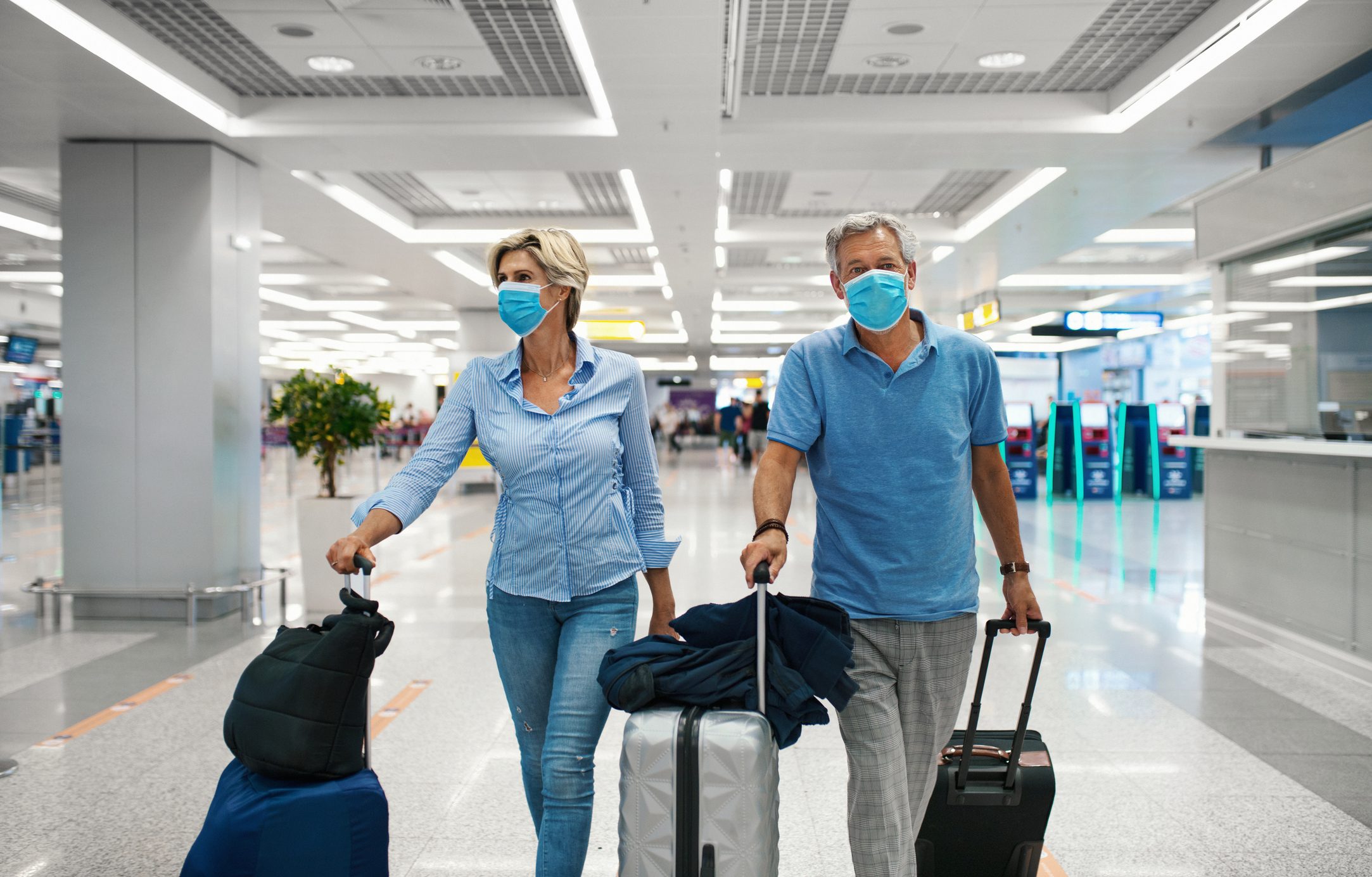 Middle aged couple at an airport during coronavirus pandemic.