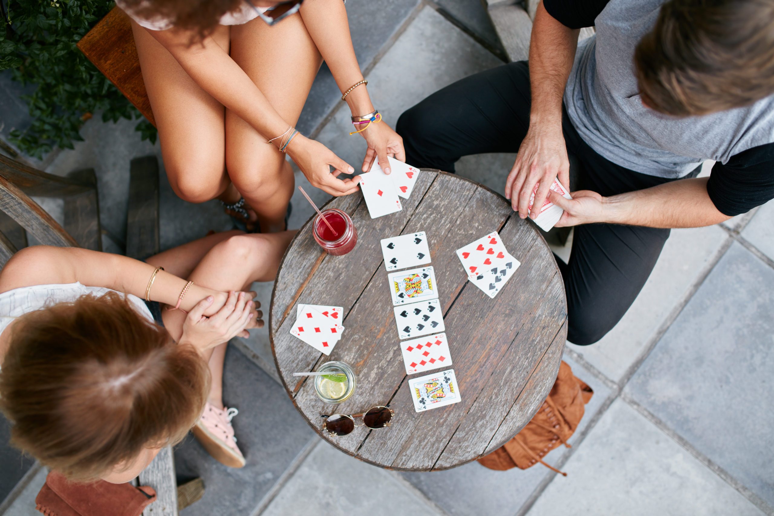 Young people playing cards at sidewalk cafe