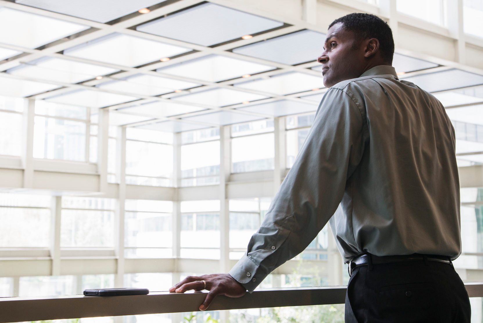 Black businessman leaning on window