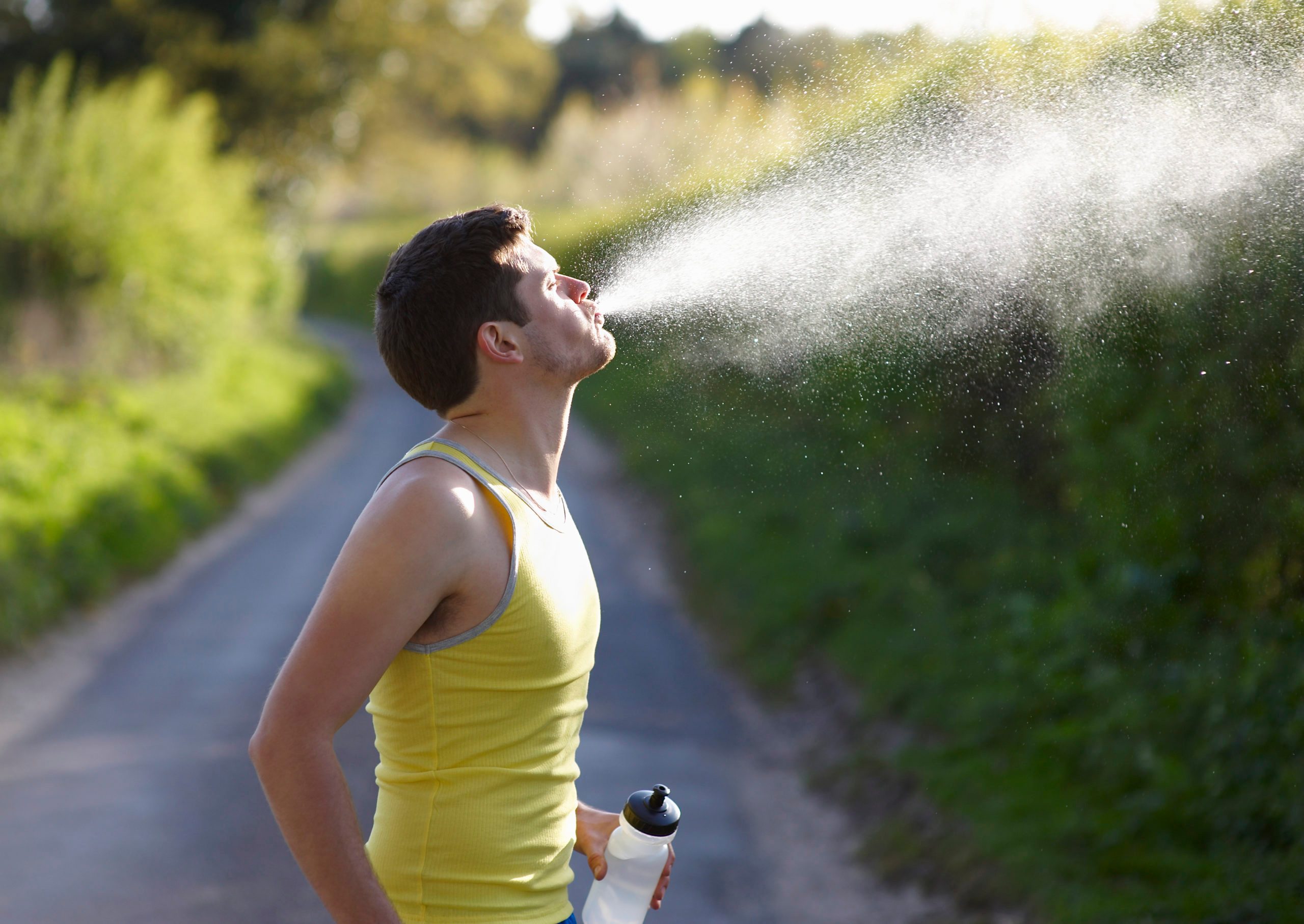 Young runner spitting out water.