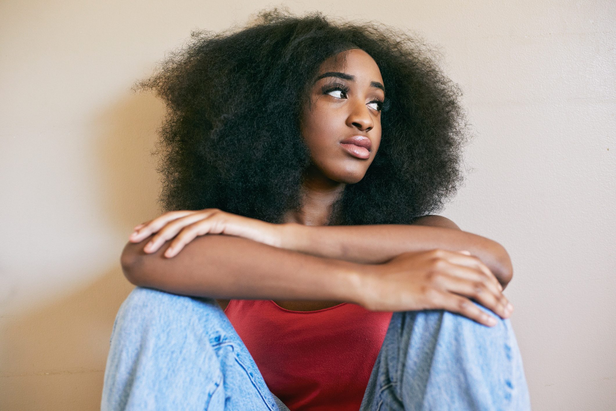 Mixed race woman sitting with arms crossed
