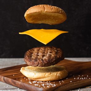Exploded Hamburger Cheese and Buns on a cutting board against a dark background