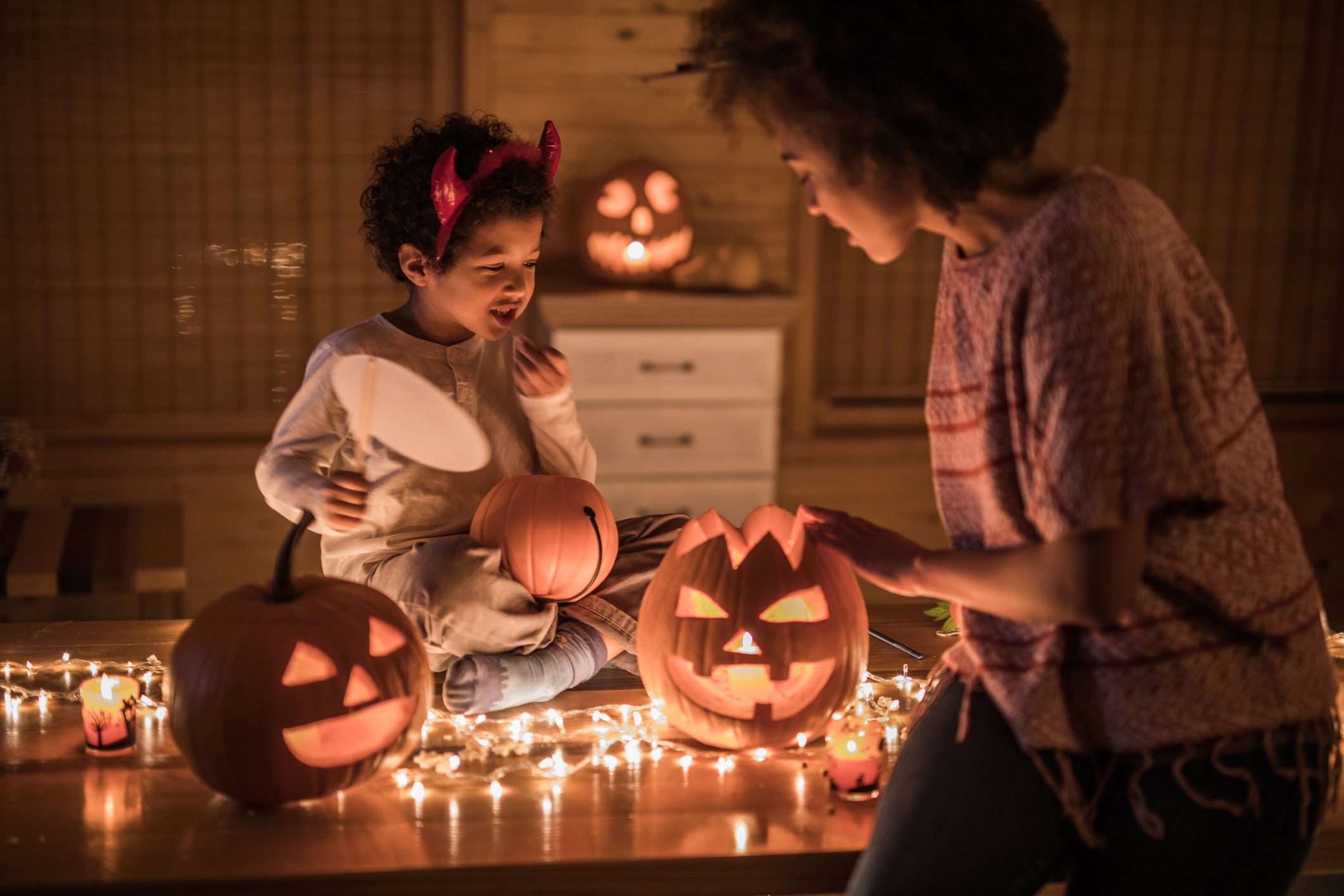 African American mother and her son preparing for Halloween party at home.