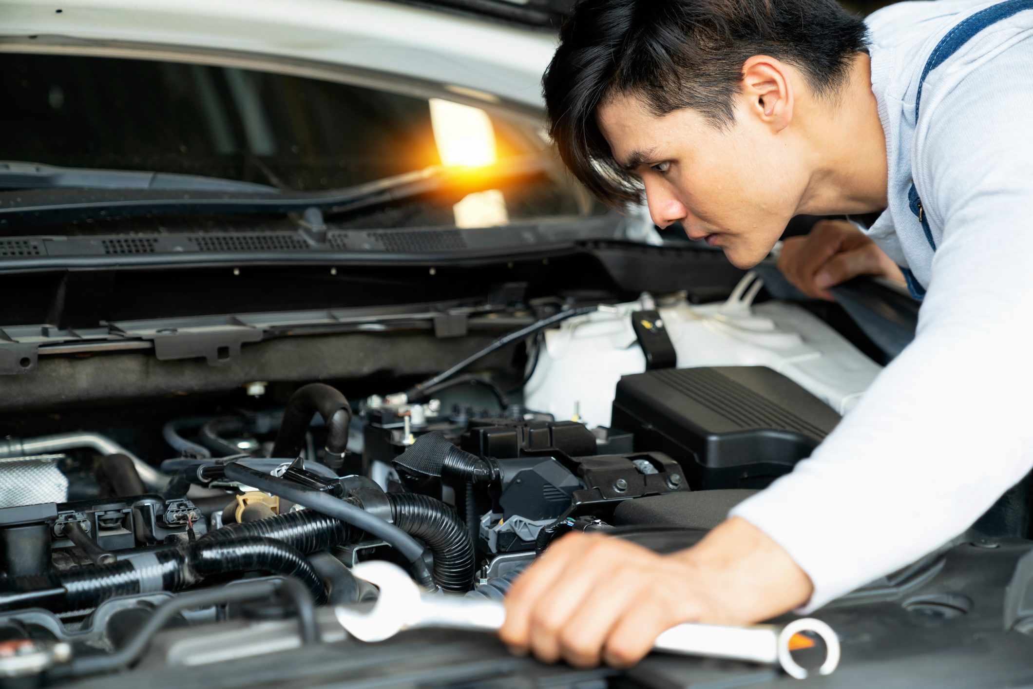 Mechanic fixing car engine in auto repair shop.Auto mechanic working in garage. Repair service.