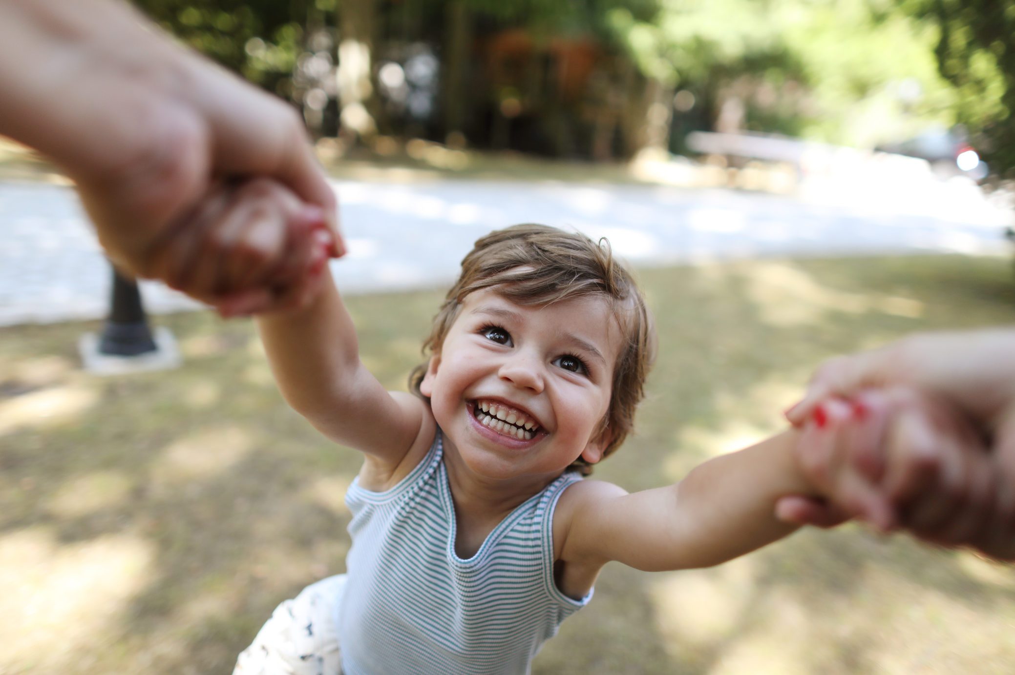 A 3 years old boy having fun in the arms of his mum