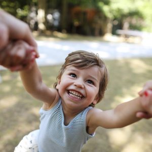 A 3 years old boy having fun in the arms of his mum