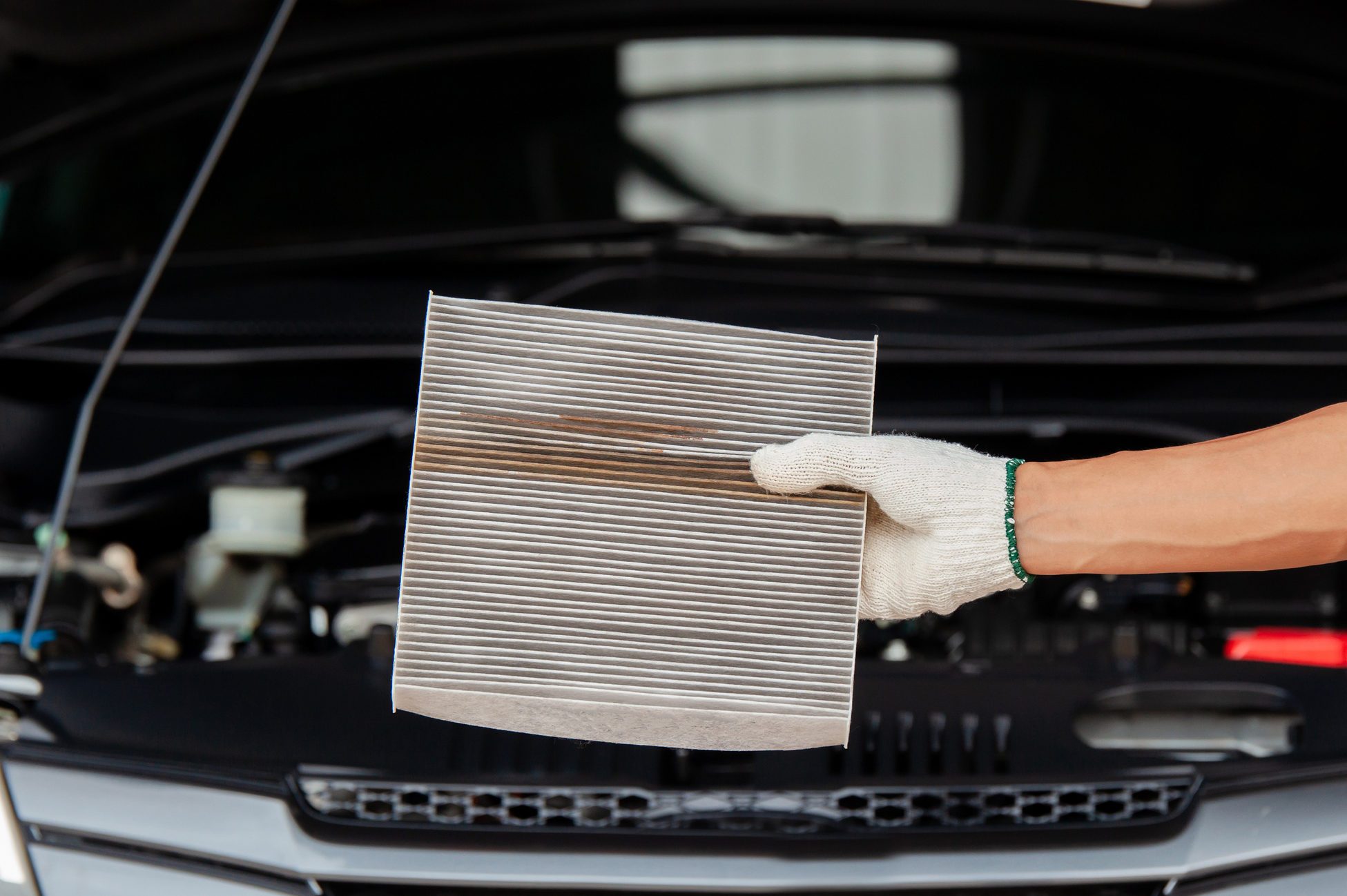 close up of Auto mechanic hands checking an air filter in garage.