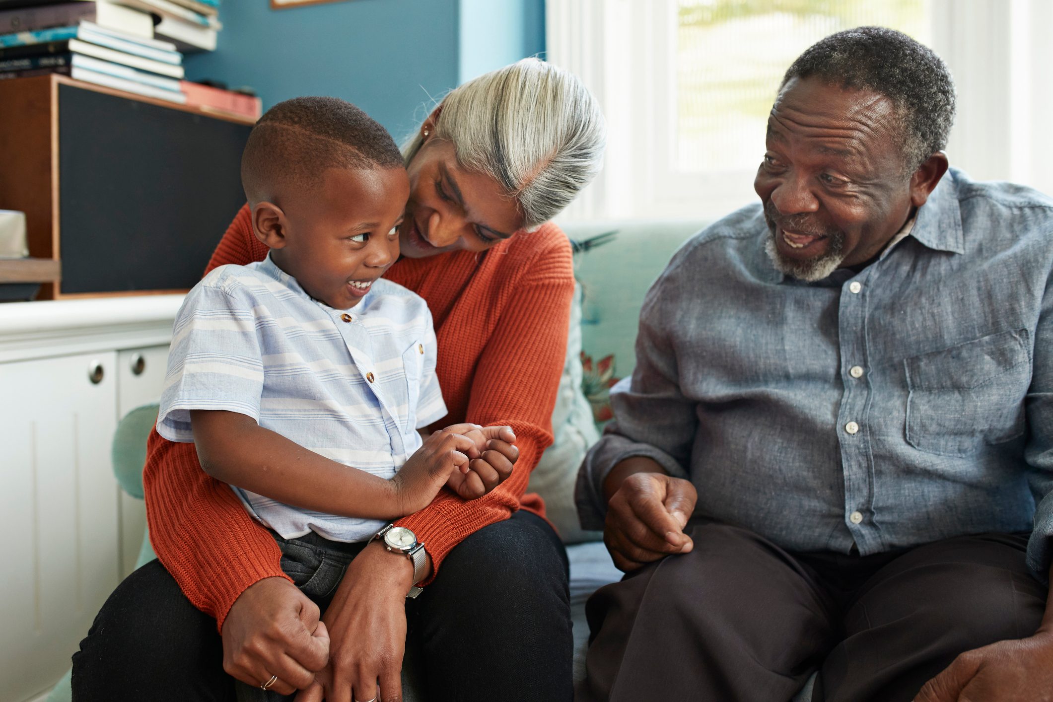 Happy man talking with cute boy standing at home