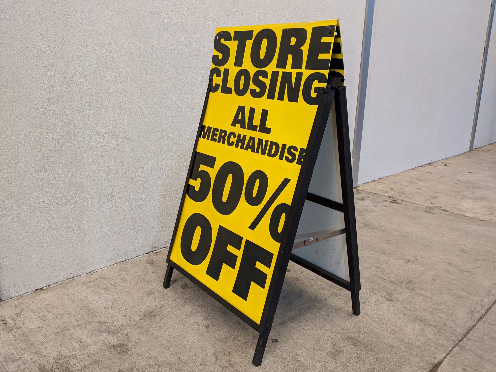 Store Closing 50% Off sign outside of a liquidated business