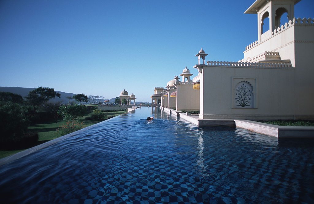 A guest swims in the moat-like pool that stretches along the...