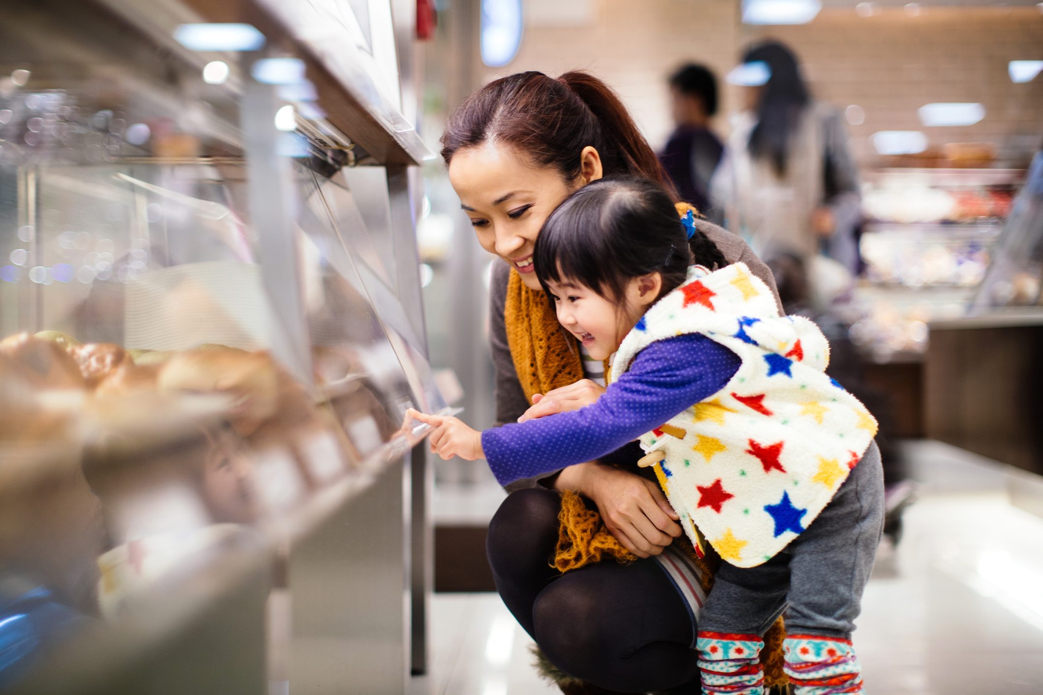 Mom & toddler girl shopping bread in the bakery