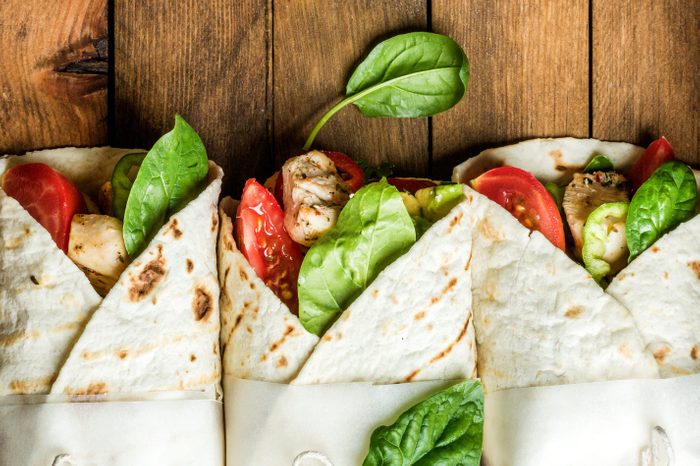 Healthy lunch snack. Tortilla wraps with grilled chicken fillet and